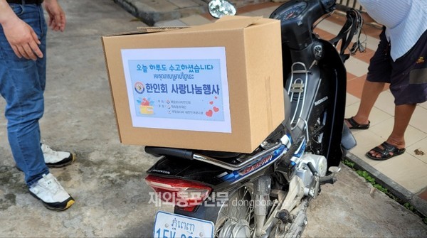 독거 어르신들과 어려운 교민들을 돕기 위한 제11차 사랑나눔행사에서 제공한 생필품 박스를 오토바이에 싣고 있는 교민의 모습 (사진 박정연 재외기자)