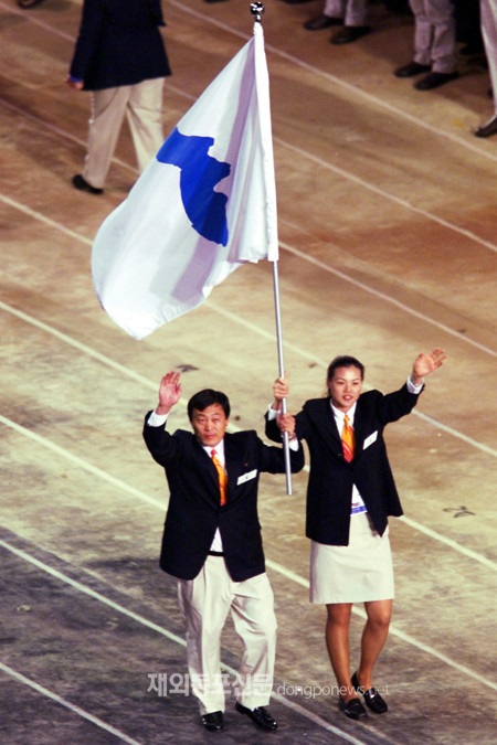 사진은 지난 2000년 9월 15일 열린 시드니 올림픽 개막식에서 사상 처음으로 남북한 대표팀이 한반도기를 들고 공동 입장하는 모습. 남측 기수는 농구의 정은순, 북측 기수는 유도 감독 박정철이 맡았다. (자료 민주평통 아태지역회의) 